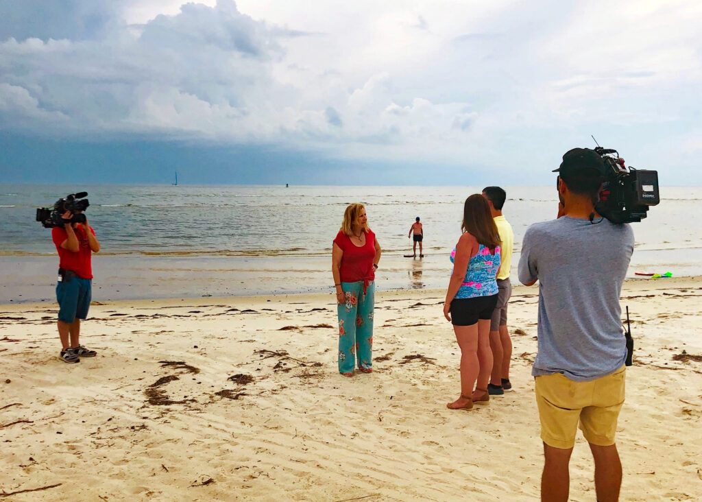 Lisa filming an episode of HGTV's Beachfront Bargain Hunt on the Cape Charles beach.