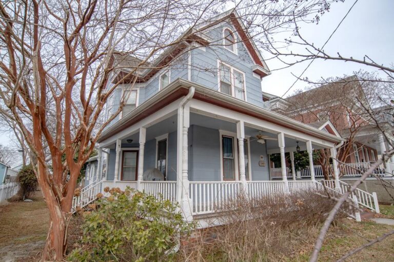 Cape Charles Virginia home with wraparound porch and mature trees — selling a home that needs repairs