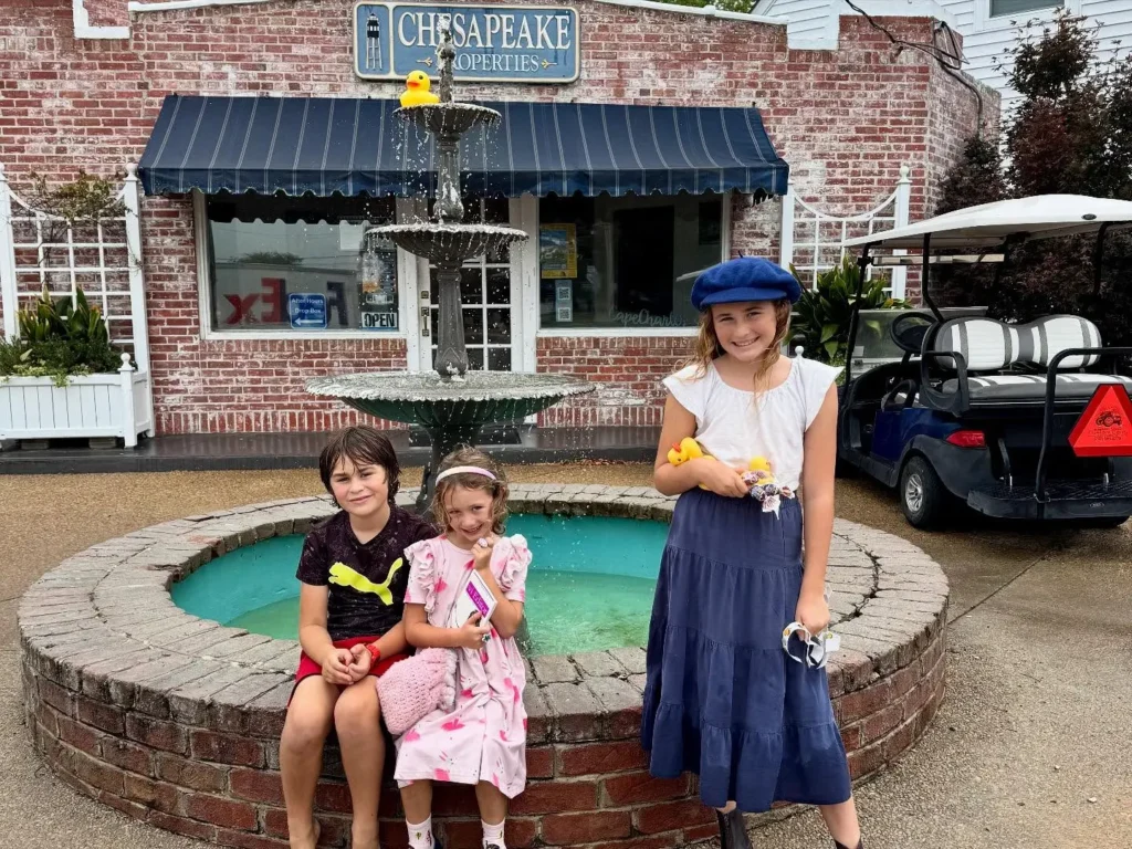 Three children posing at the fountain in front of the Chesapeake Properties office in Cape Charles, Virginia