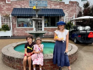 Three children posing at the fountain in front of the Chesapeake Properties office in Cape Charles, Virginia