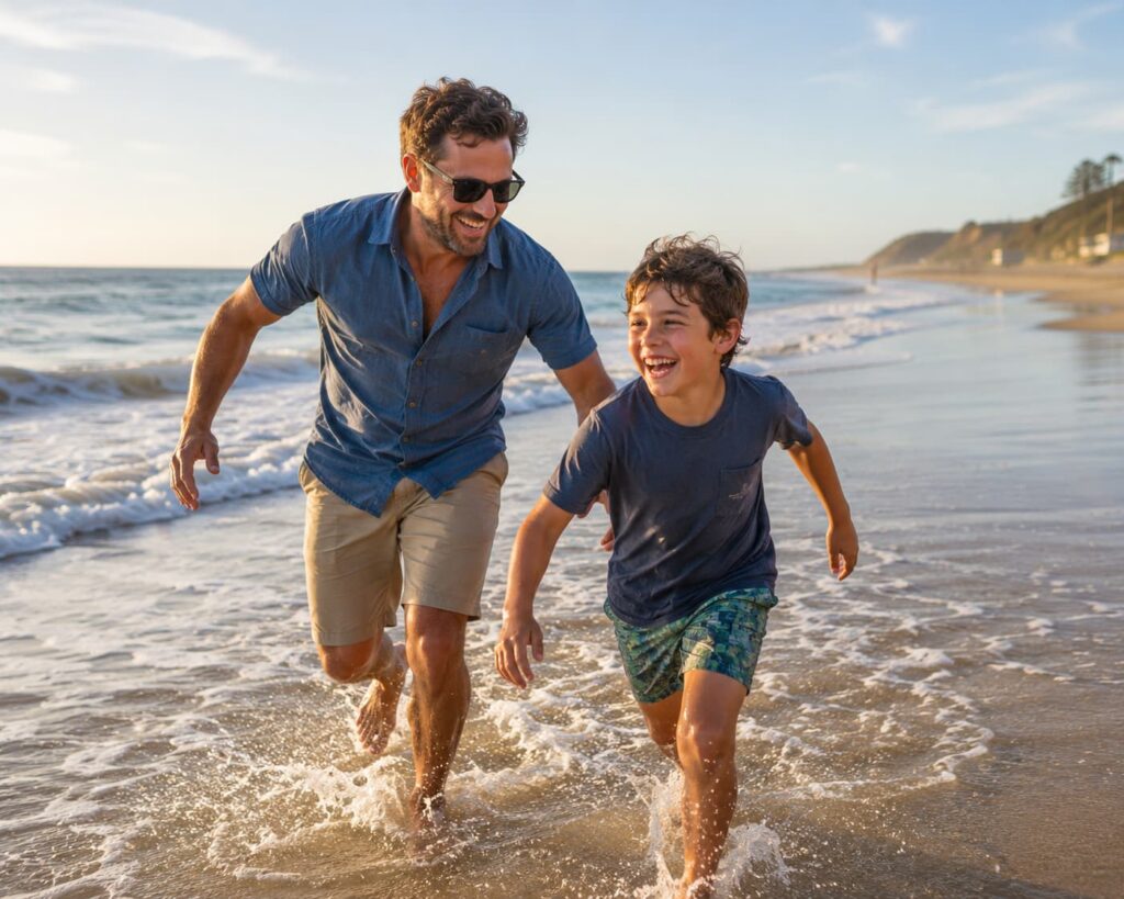 Father's Day Cape Charles celebration featuring a father and son laughing and playing together along the beach shoreline, splashing through the waves and enjoying a memorable summer day by the water