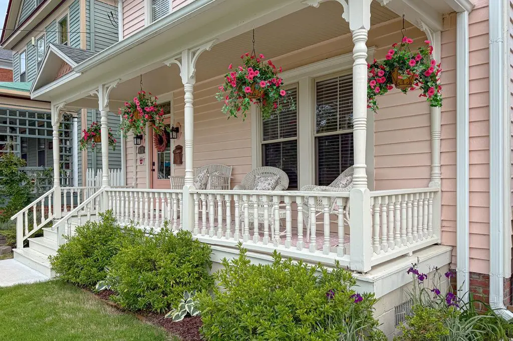 Victorian vacation home with wraparound porch and hanging flower baskets at 612 Tazewell Ave Cape Charles Virginia — how to buy a vacation home in Virginia