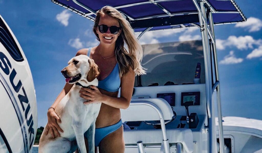 Woman and dog enjoying a day boating on the Chesapeake Bay near Cape Charles, part of the waterfront homes in Cape Charles lifestyle