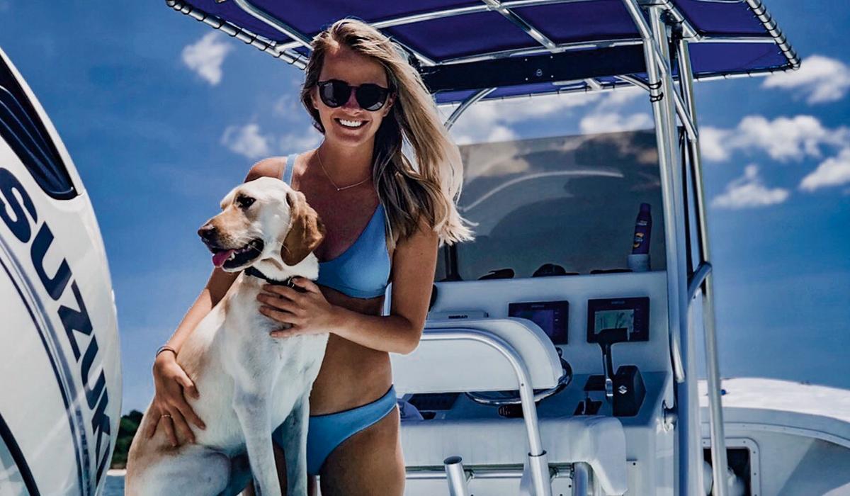 Woman and dog enjoying a day boating on the Chesapeake Bay near Cape Charles, part of the waterfront homes in Cape Charles lifestyle